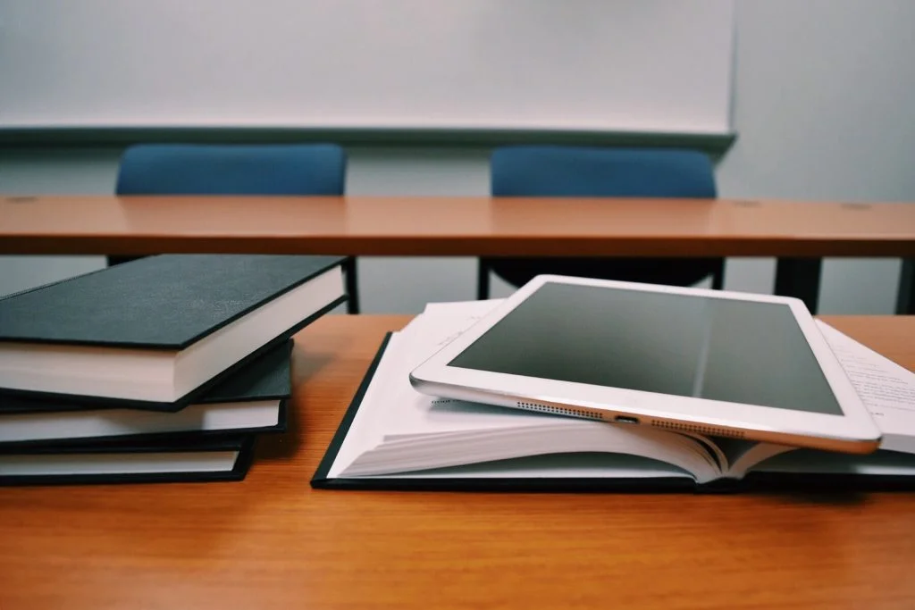 Biały tablet leżący na otwartej książce